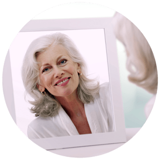 dental implant patient looking in mirror smiling